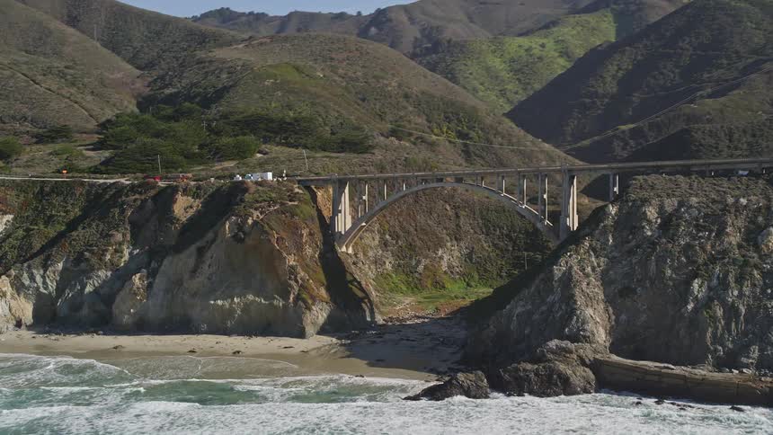 Landscape of a bridge connecting two mountains on the rocky coast by the sea