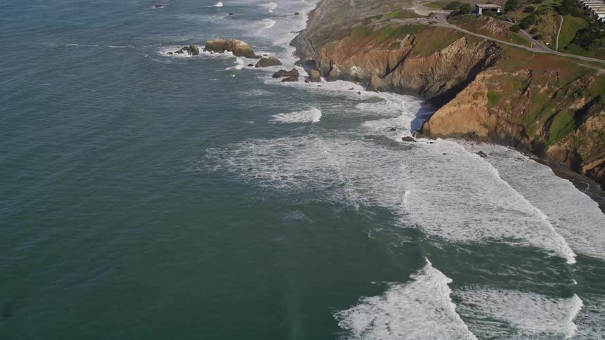 Aerial view of a rugged coastline with waves crashing against rocks