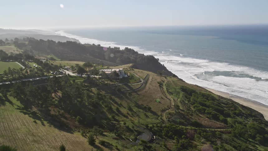 Aerial view of highway and mansions on hills by the sea