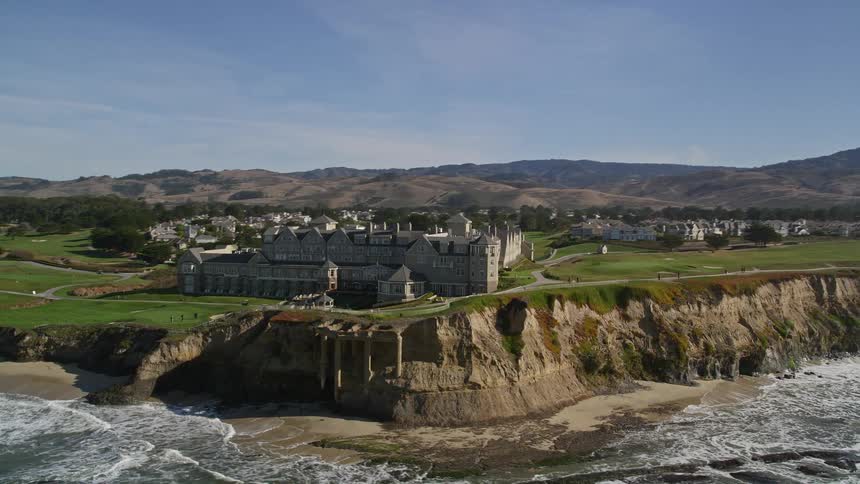 The ritzcarlton half moon bay is located on a cliff overlooking a dramatic oceanfront golf course