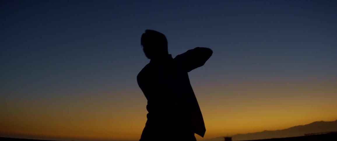 Lonely silhouette dancing against the sunset with shades of yellow and blue