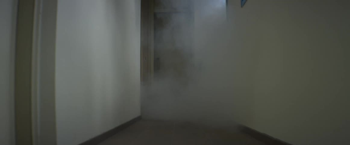 Smoke seeping under a doorway and into the hall