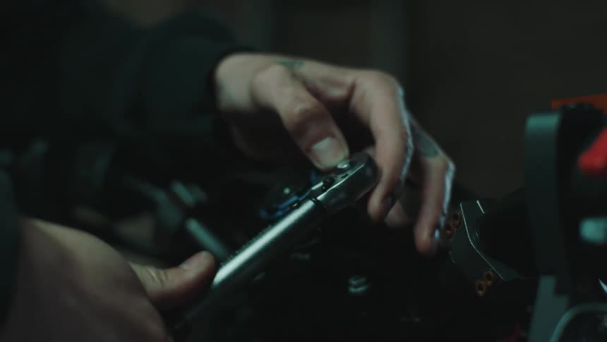 Male mechanic uses wrench while working on machine