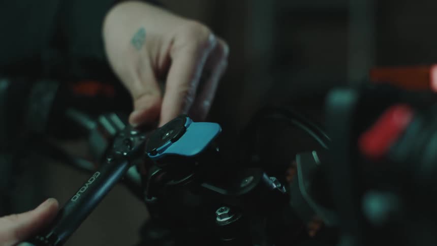 Close up of the hands of a person using a ratchet to adjust gears