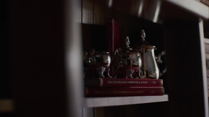 A shelf with books and silverware