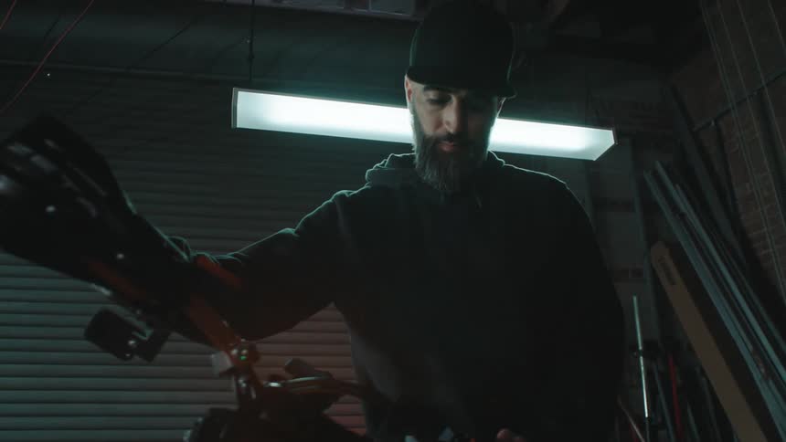Man repairing motorcycle in a garage tests the lights