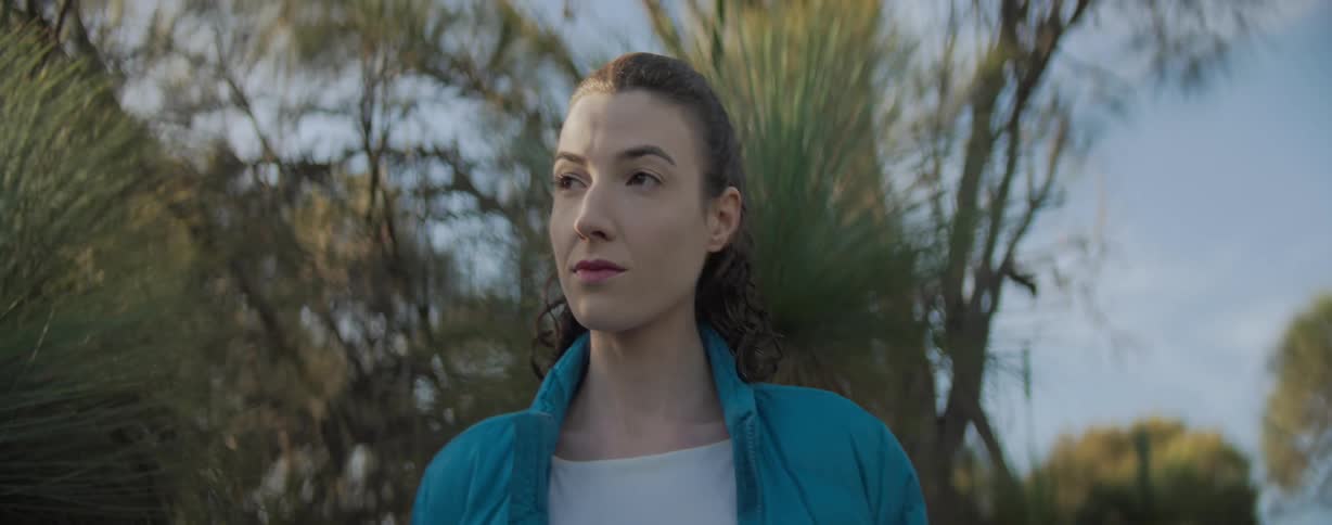 Woman walking outdoors pauses briefly to look around
