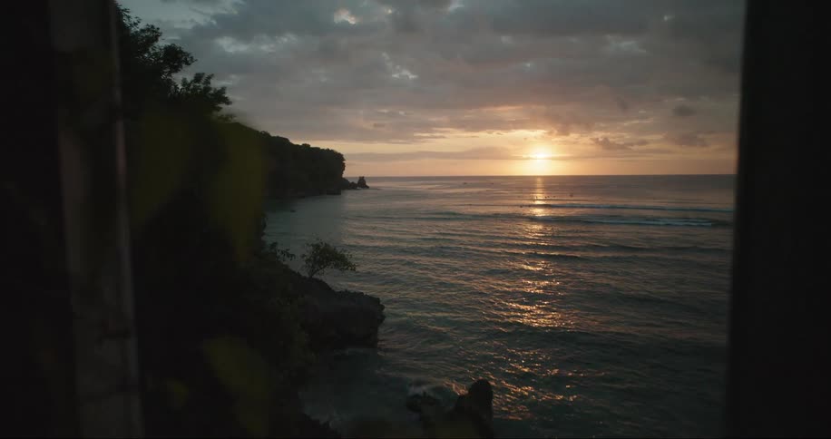 Landscape from the window of a house with a view of the sea and the sunrise on the horizon