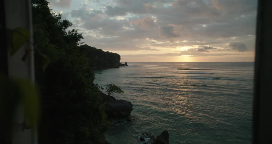 The sun is rising on the shore