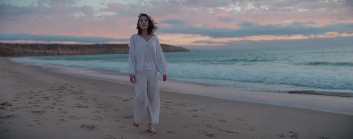 A woman is walking on the beach