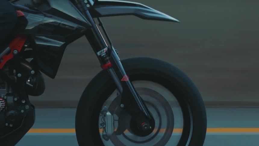 The tires of a motorcycle rolling quickly on an asphalt street