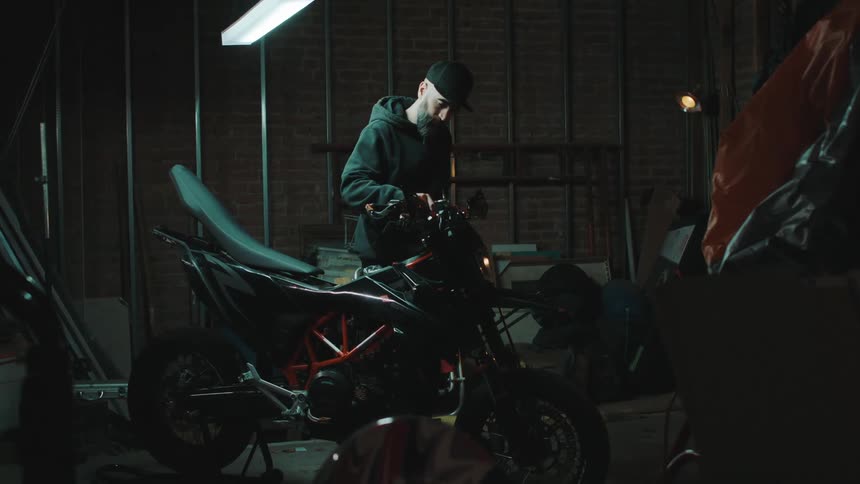A man is working on the motorcycle in the shop