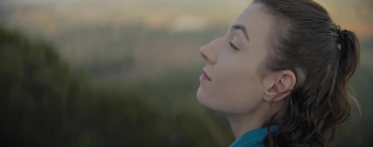 A womans face is shown taking in the nature around her
