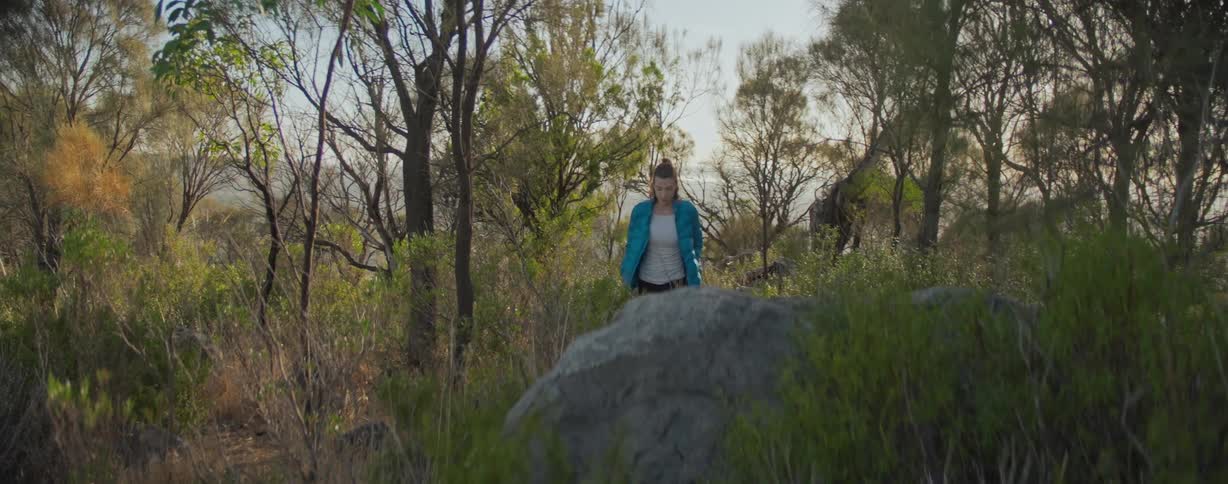 A woman is hiking in the woods