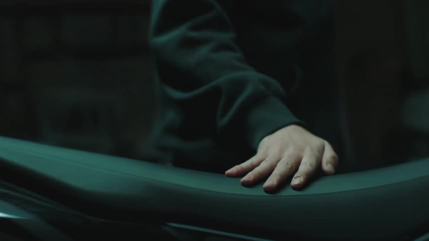 Man putting a black leather seat on a motorcycle