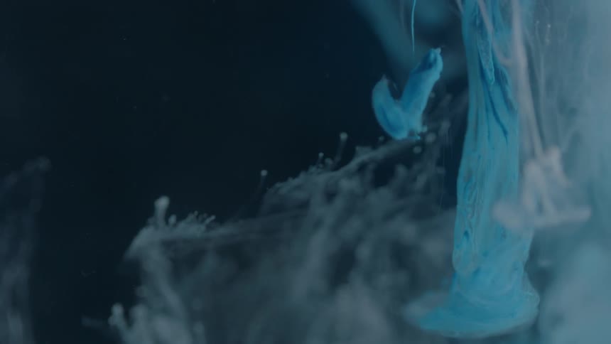 Blue and white dye dropped into liquid