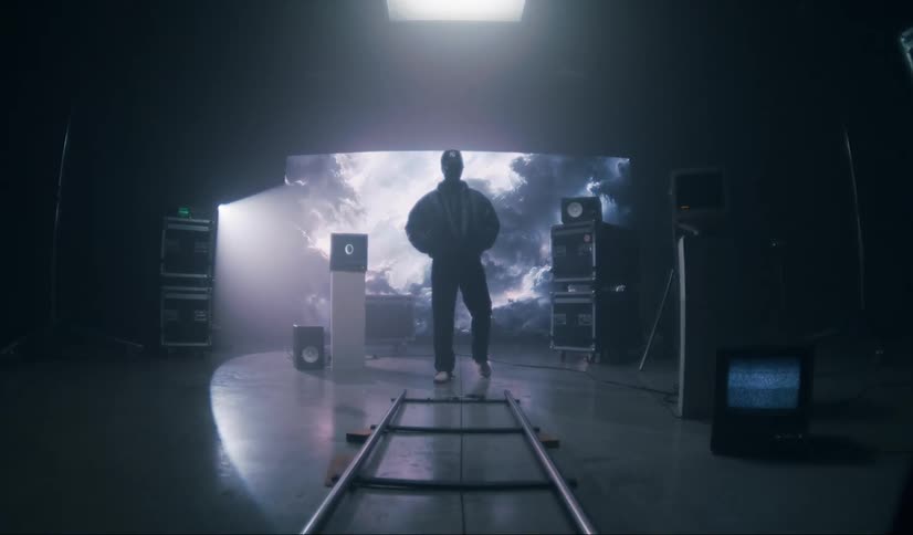 Man stands silhouetted against large screen on dimly lit film set