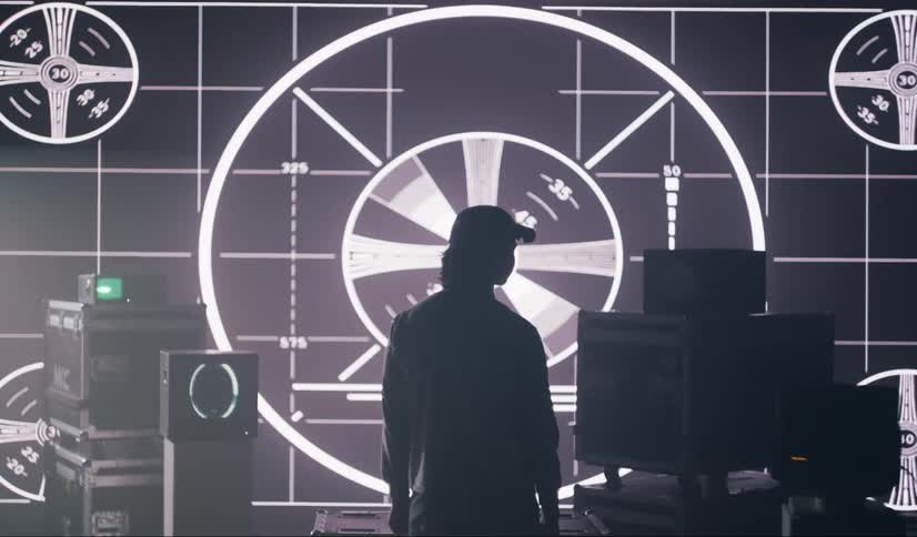 A man stands in the dark in the studio