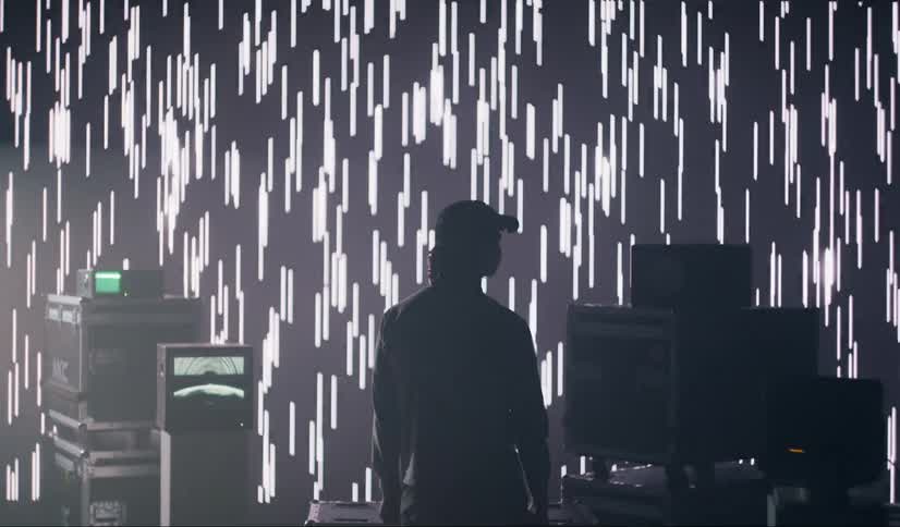 A man watches the lights flash on the wall in the studio