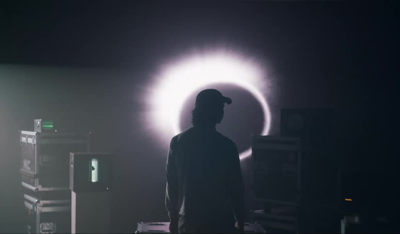 A person is on their back looking at a huge screen that is showing black and white space images
