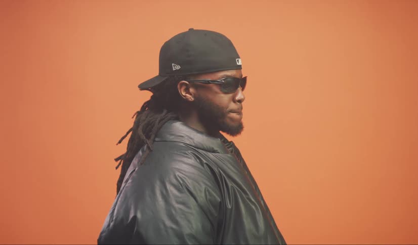 Man wearing a puffy coat stands against a red background
