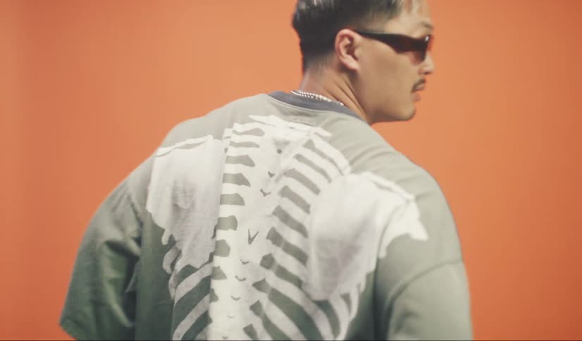 A man is modeling a shirt with a skeleton design on the back