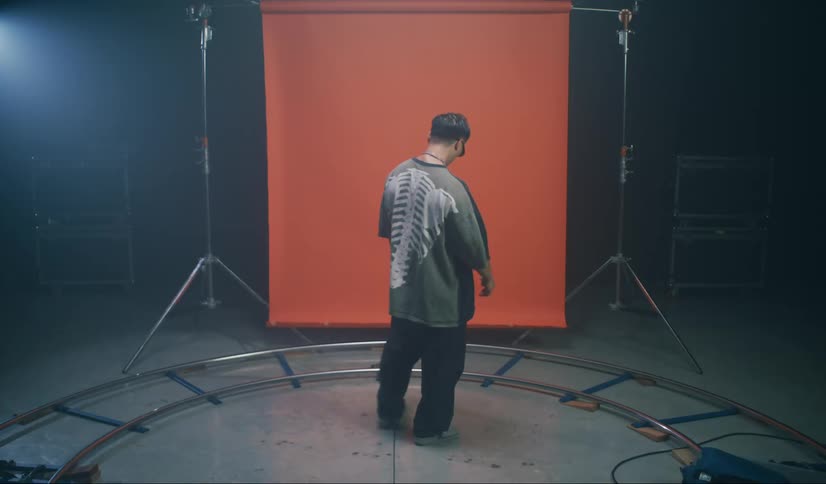 Man with sunglasses in a studio with cinematic lighting and an orange banner in the background