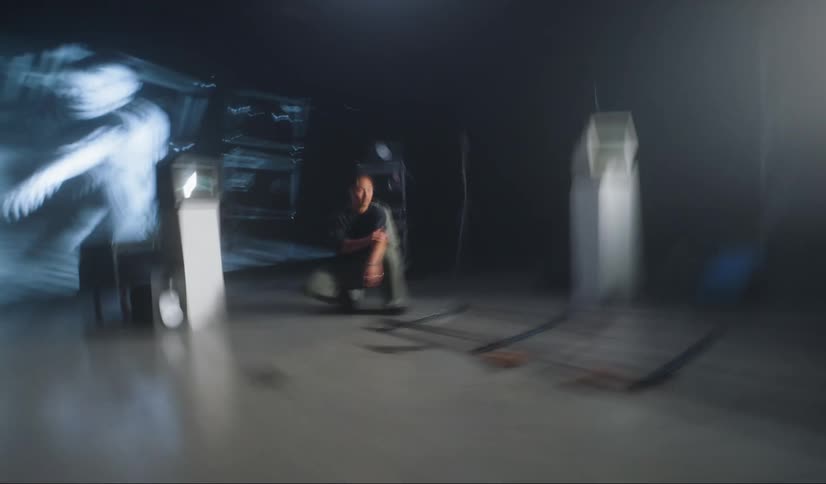A man crouching on a studio surrounded by filming equipment