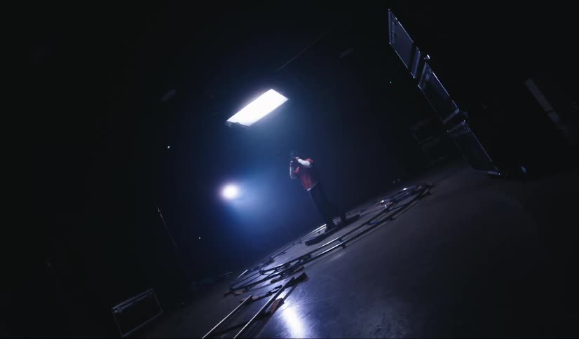 Man walks on treadmill surrounded by camera track at a set