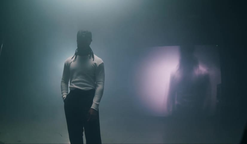 Model man in a movie studio with his image appearing on a screen in the background