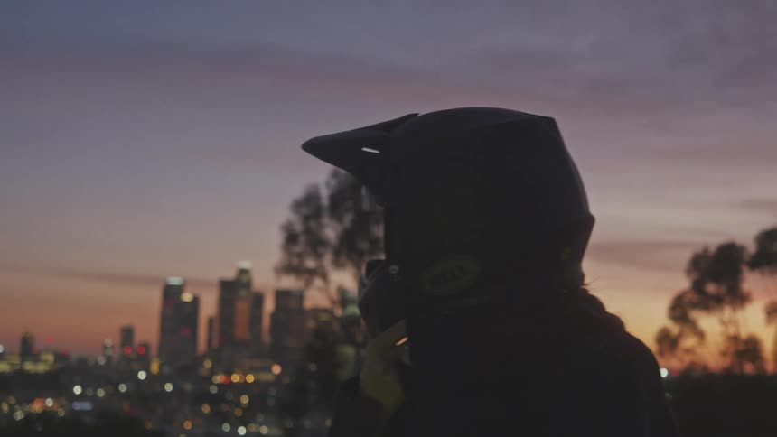 A woman straps the motorcycle helmet on her head