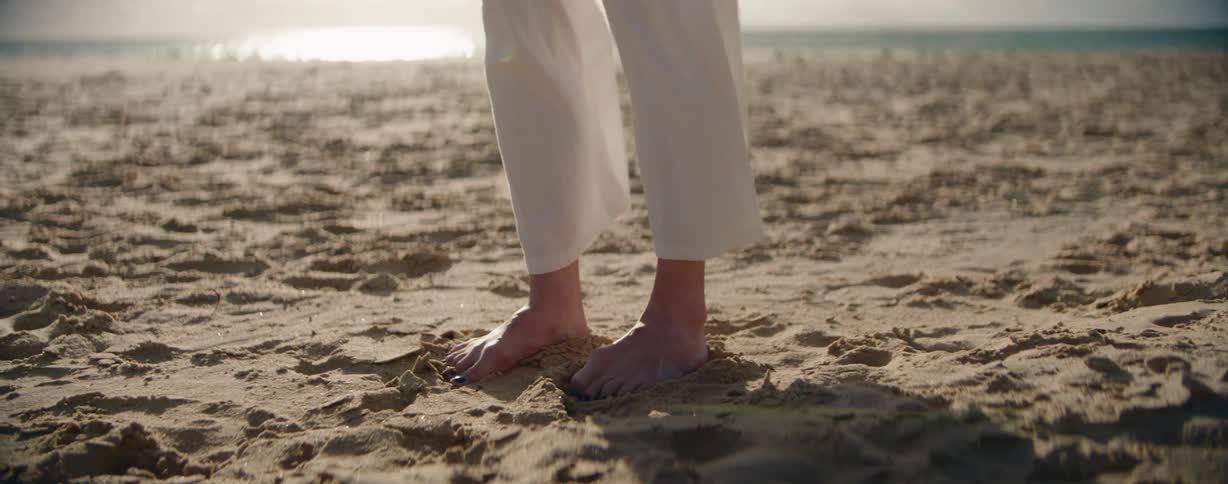 Womans feet in the sand on the beach