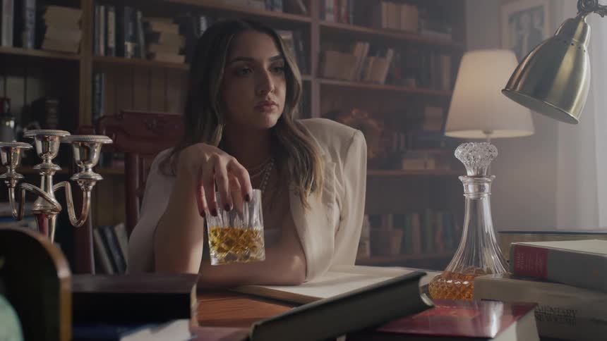 A woman is drinking at the desk