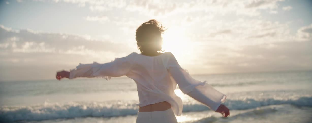 A woman is dancing on the beach