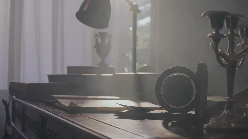 Various inanimate objects on a wooden table being styled by sunlight coming from the window
