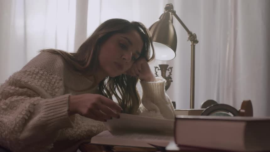 A woman is reading books at the desk