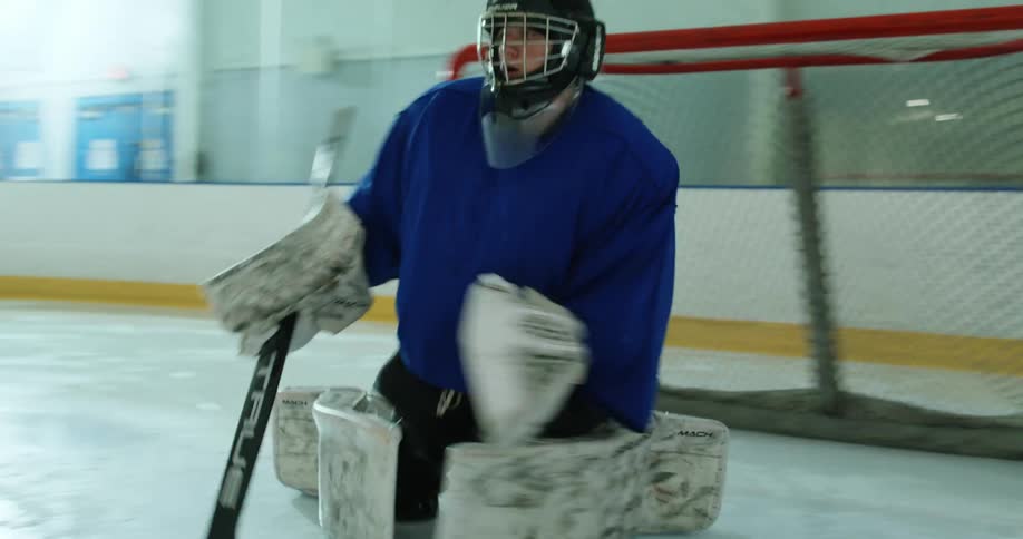 Goalie practices moves to save a goal on a hockey court