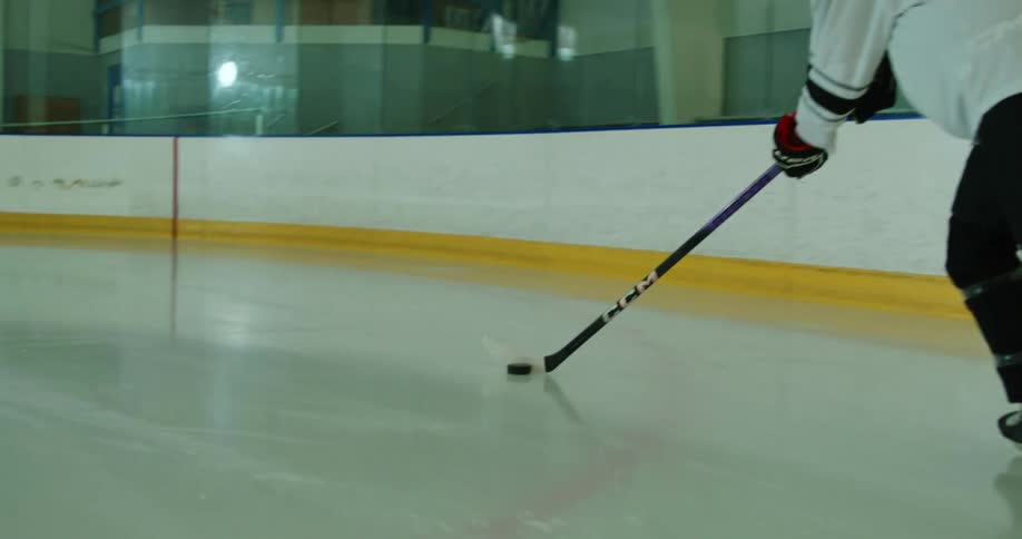 Hockey players play hockey at an indoor ice rink