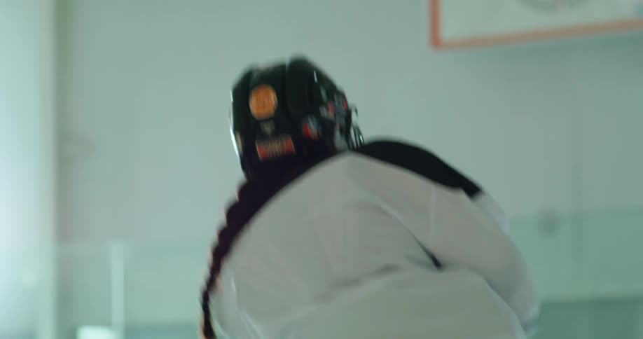 Female player with a hockey stick shooting towards the goal against a goalkeeper in training on the hockey court