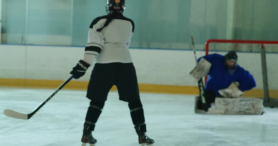 A hockey player shoots the puck at the net