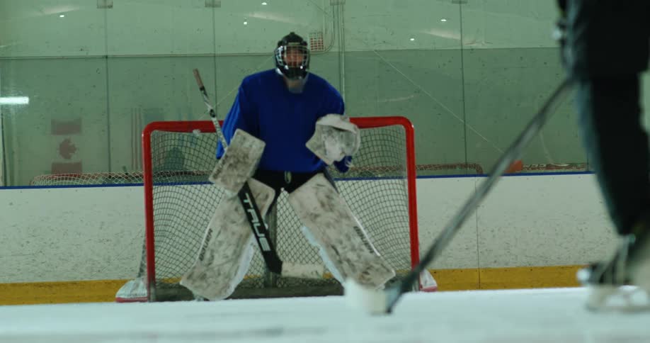 A hockey player scores on the goalie