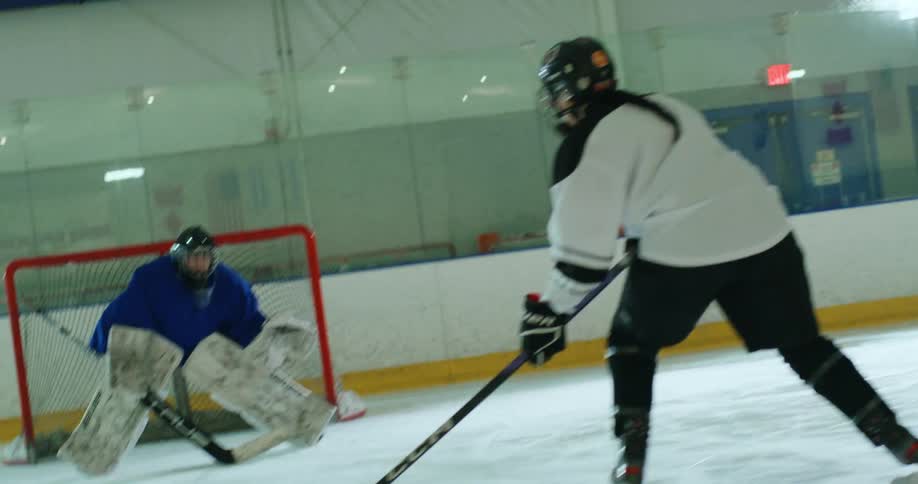 Two women training on a hockey court