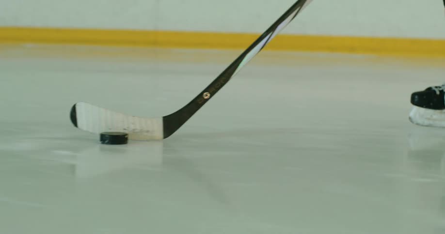 A player chases and shoots a puck on an ice hockey rink