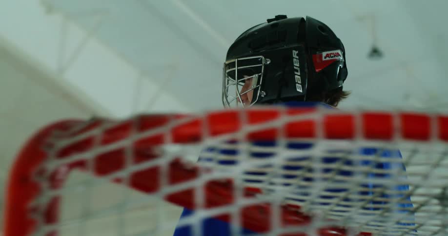 A goalie protects the net in the hockey game