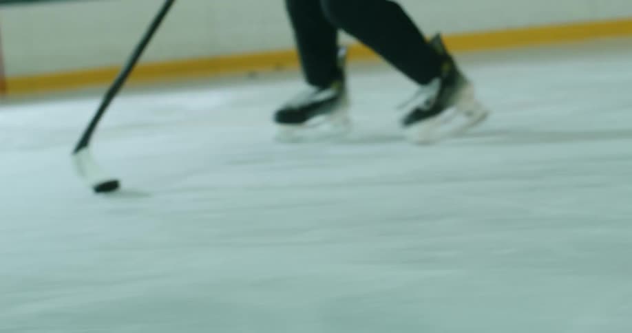 Person driving a sphere with a hockey stick on an ice court