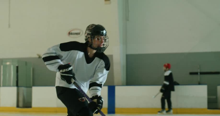 A hockey player pushes the puck across the ice