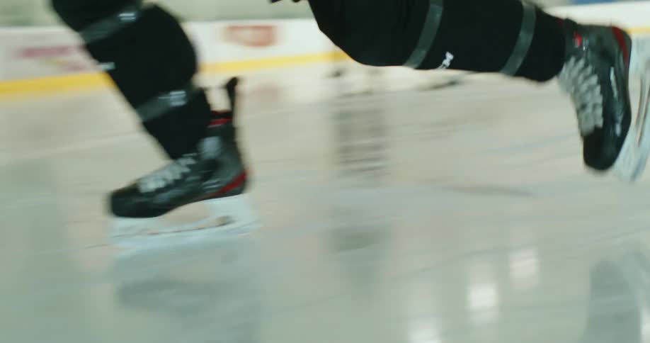 A hockey player takes a shot on the goal on a n ice hockey rink