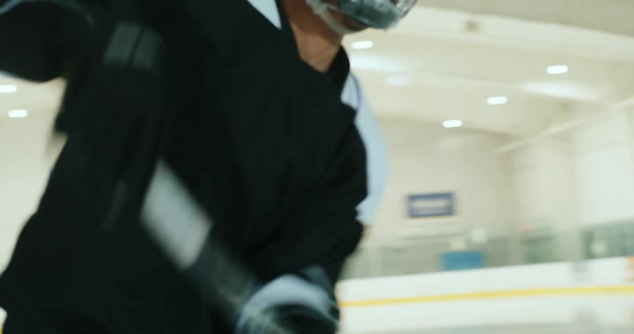 A hockey player takes a shot on goal while practicing at an ice rink
