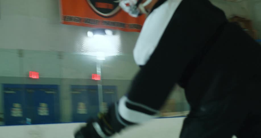 A hockey player in full gear practicing and scoring a point