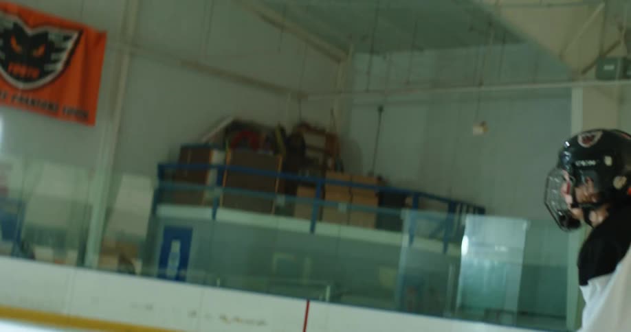 Two people on an ice court playing hockey